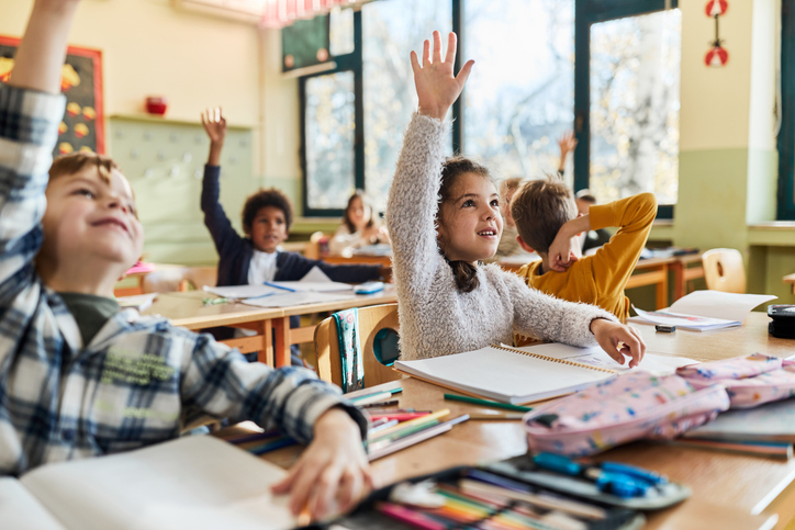 Happy schoolgirl and her friends raising hands on a class. k-12 crisis communications. Dave Smolensky, incident response planning, tabletop exercise